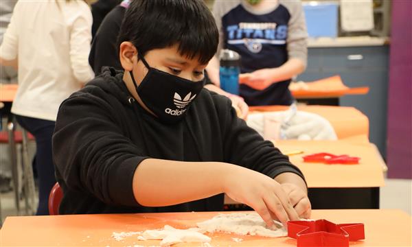 Boy cuts out shape from salt dough